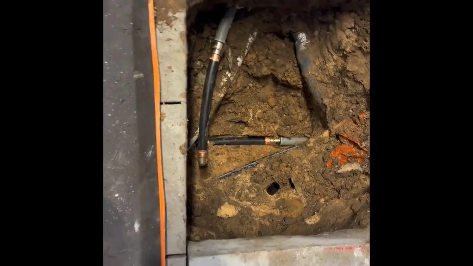 A garage wall opened to reach a burst supply line during a service visit in Buford, GA